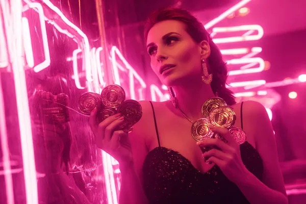 A glamorous woman holding casino chips in a neon-lit environment, representing the premium online casino atmosphere of GOOD112.